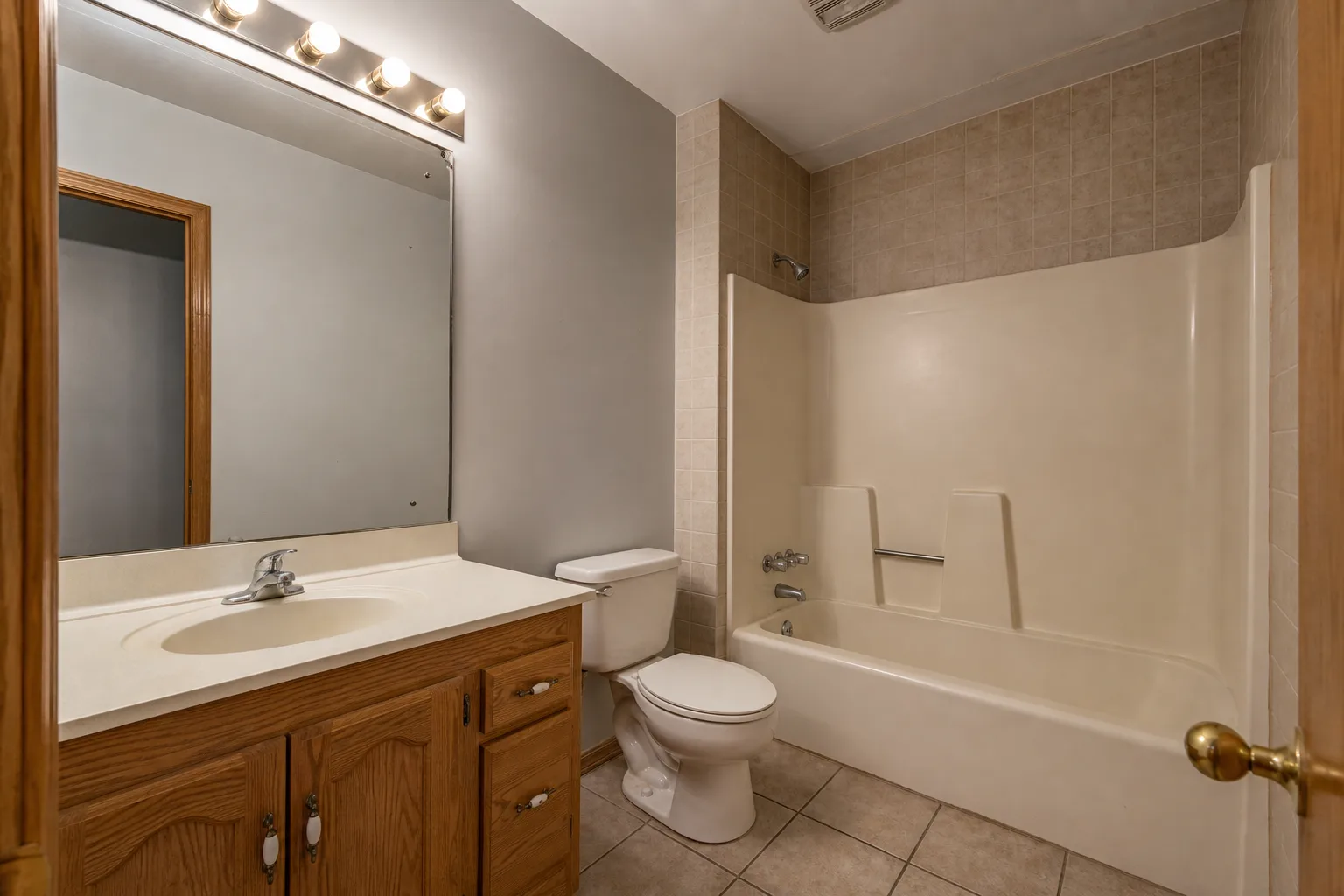 Outdated bathroom before remodel with dated vanity and tub